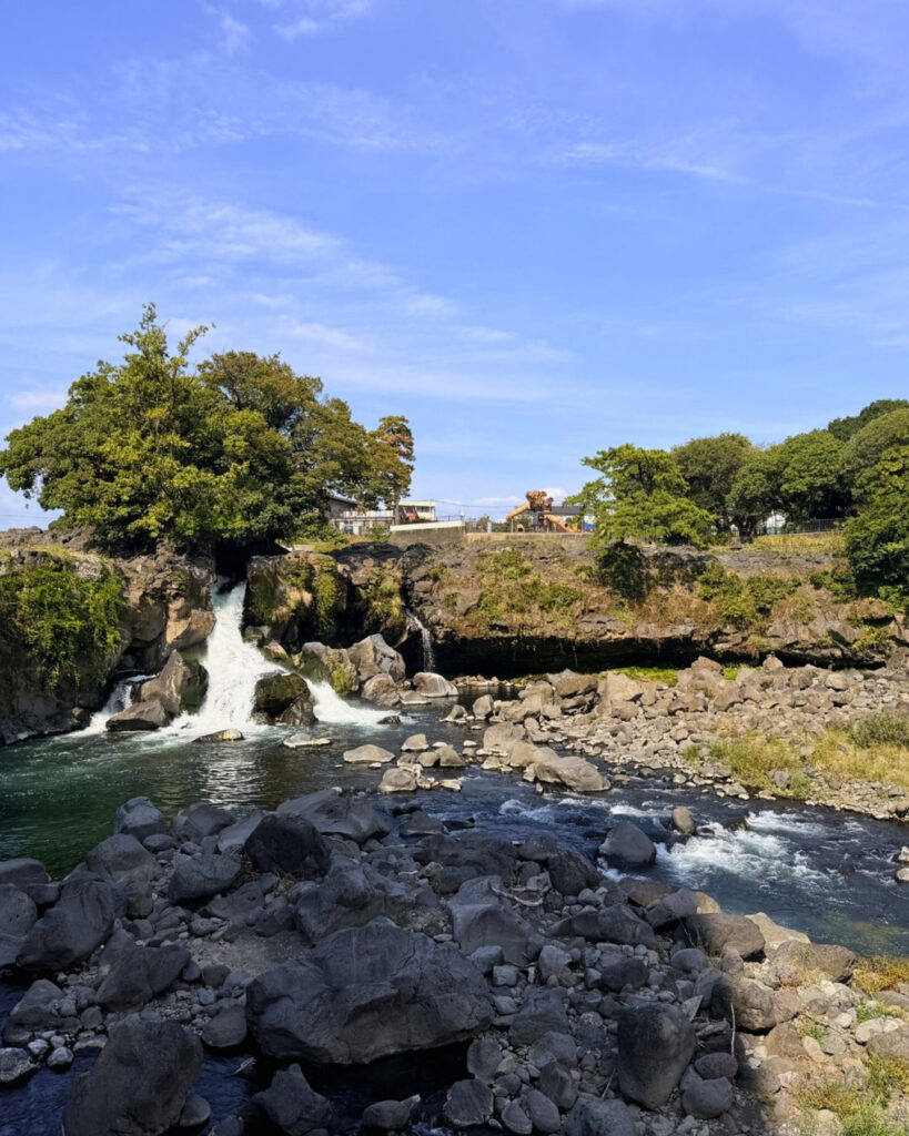 溶岩の崖から落ちる鮎壺の滝と川原
